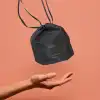 Small drawstring bag labeled Bejoyland NECKY levitates over the hand